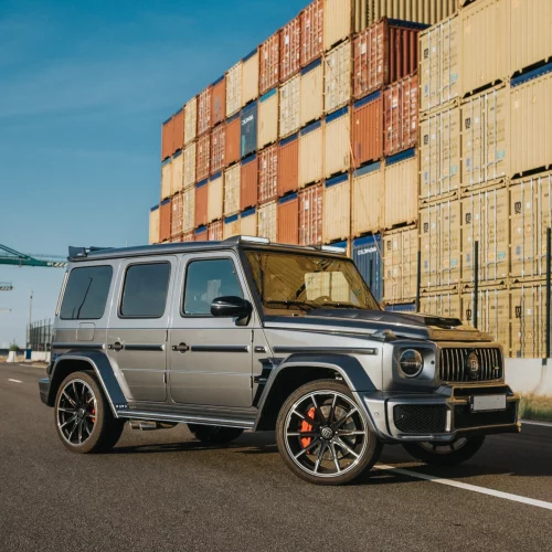 Zijaanzicht van de Mercedes-AMG G63 BRABUS bij containers.